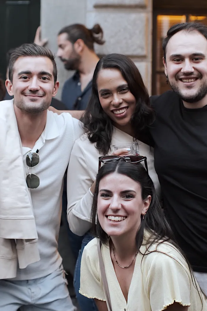 Tres miembros de la comunidad sonriendo juntos en la calle