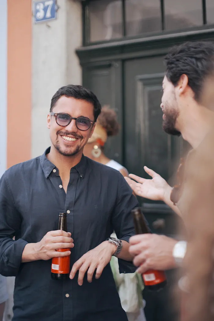 Dos miembros de la comunidad conversando y riendo con una caña en la mano